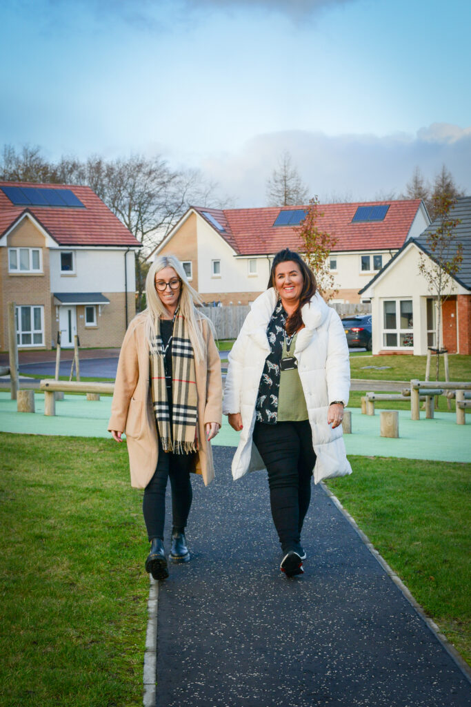 Two residents walking along a path in their neighbourhood.